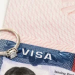 visa stamp on passport with engagement ring on top to make reference to the K1 fiance visa